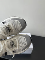 Close-up of white mesh sneaker heels and soles with Dior branding on back