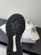 White Dior sneakers showing textured tread outsole and chunky rubber sole