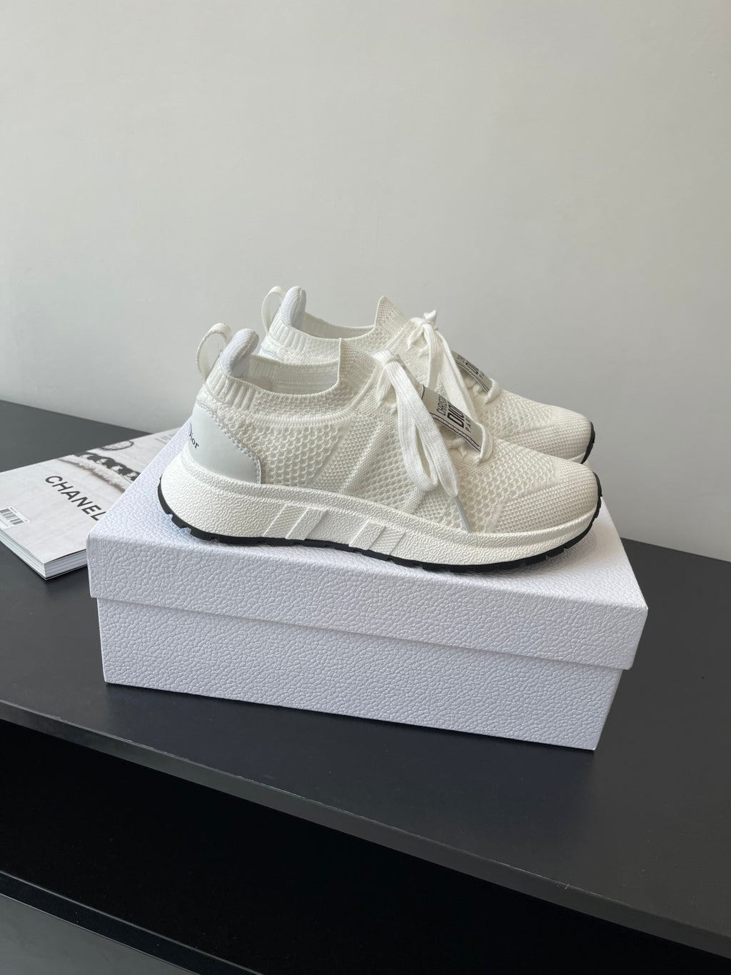 White knit Dior sneakers with lace-up ties and thick rubber sole, side view