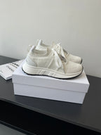 White knit Dior sneakers with lace-up ties and thick rubber sole, side view