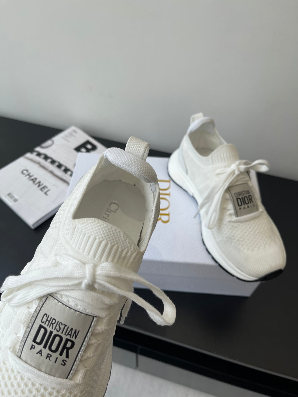 White Dior sneakers with knit fabric and lace bow; interior tag visible