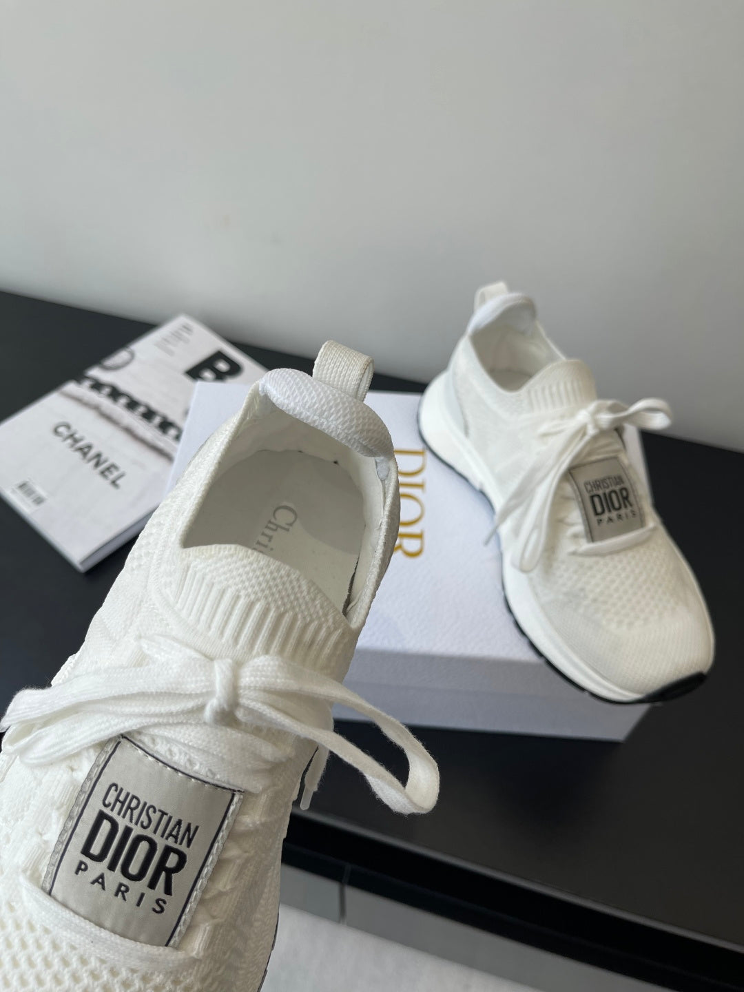 White Dior sneakers with knit fabric and lace bow; interior tag visible