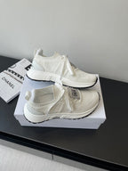 White Dior knit sneakers with lace ties and thick sole, angled on display