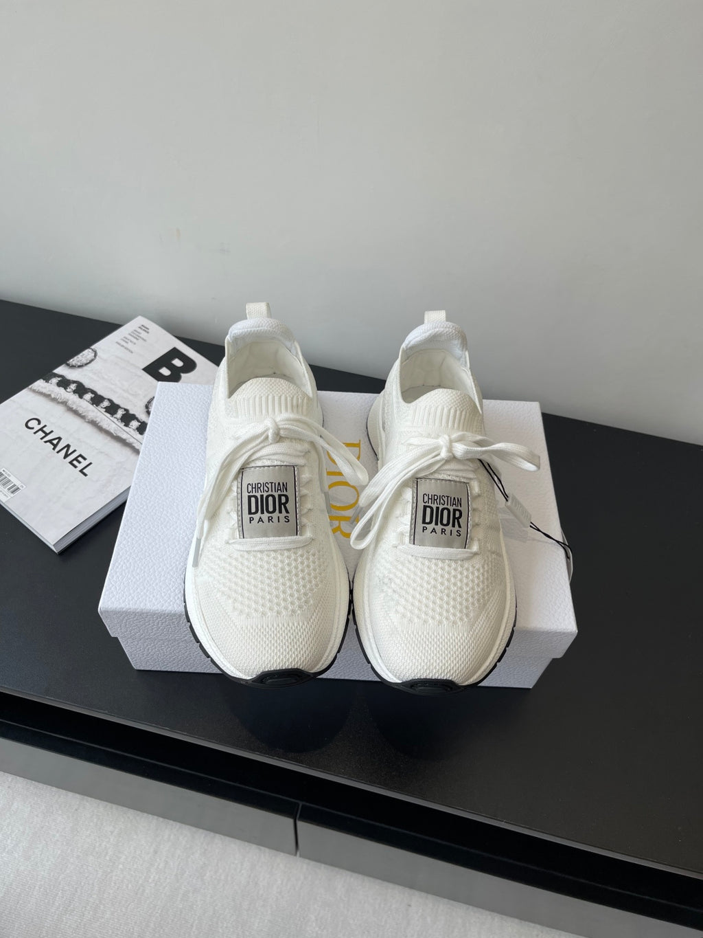 White Dior slip-on sneakers with knit upper, lace ties, and cushioned sole