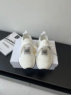 White Dior slip-on sneakers with knit upper, lace ties, and cushioned sole