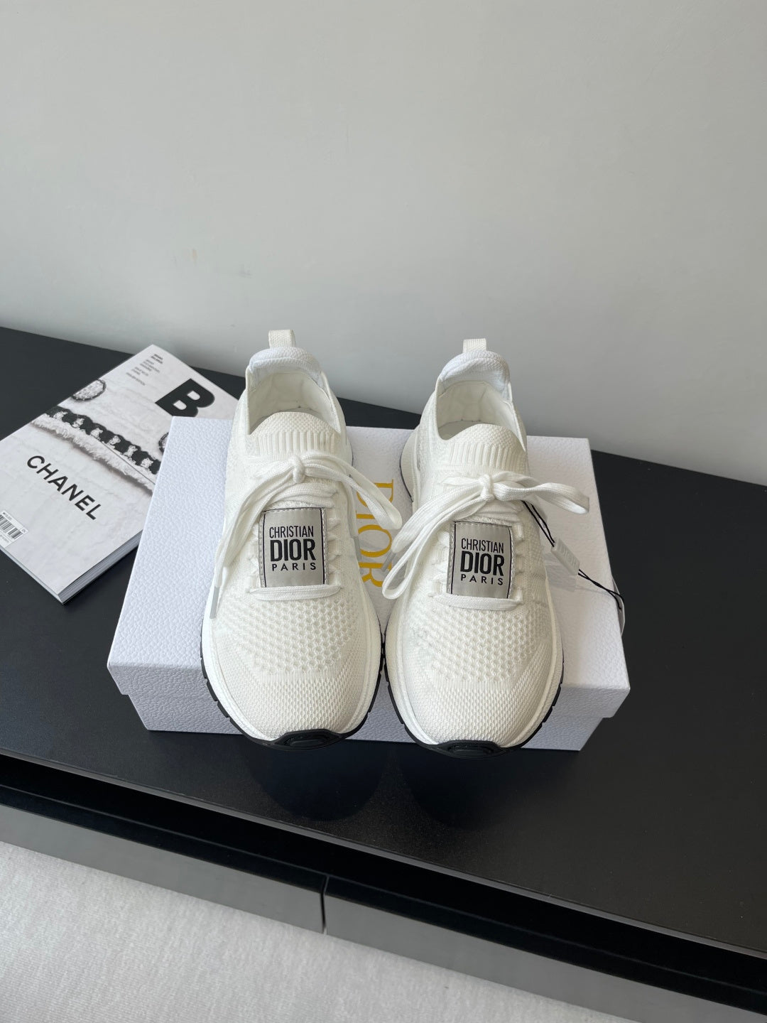 White Dior slip-on sneakers with knit upper, lace ties, and cushioned sole