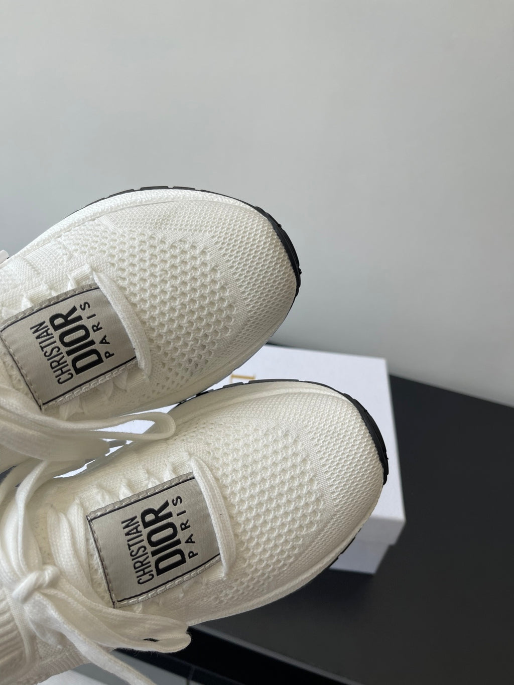 Close-up of white Dior sneakers’ knit upper and logo interior label