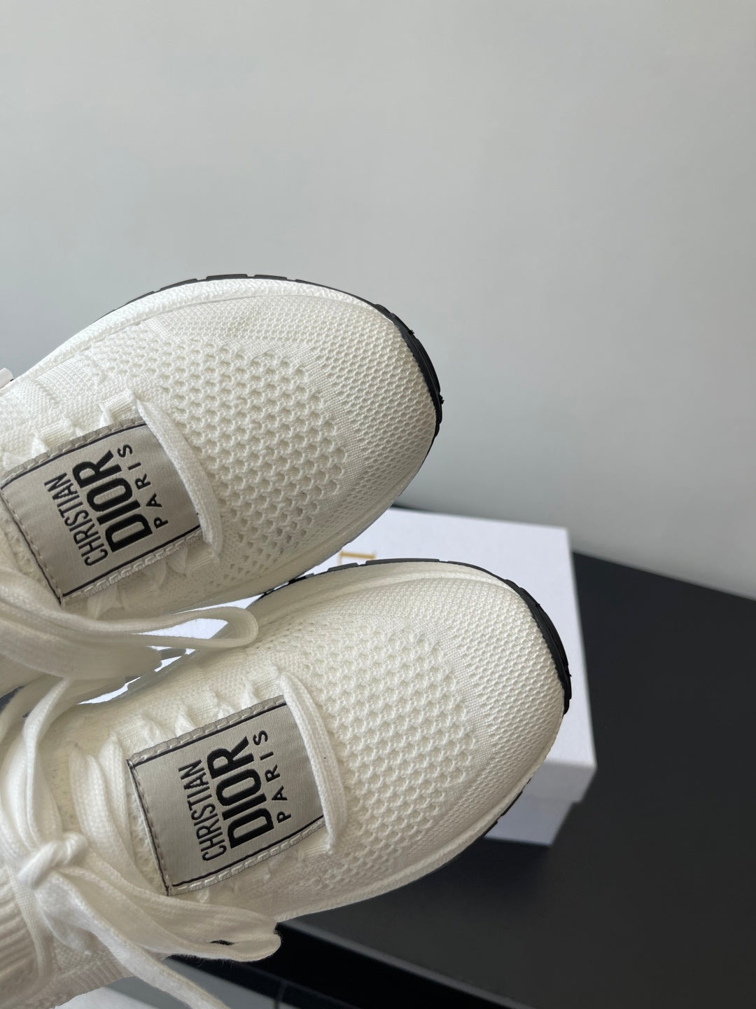 Close-up of white Dior sneakers’ knit upper and logo interior label