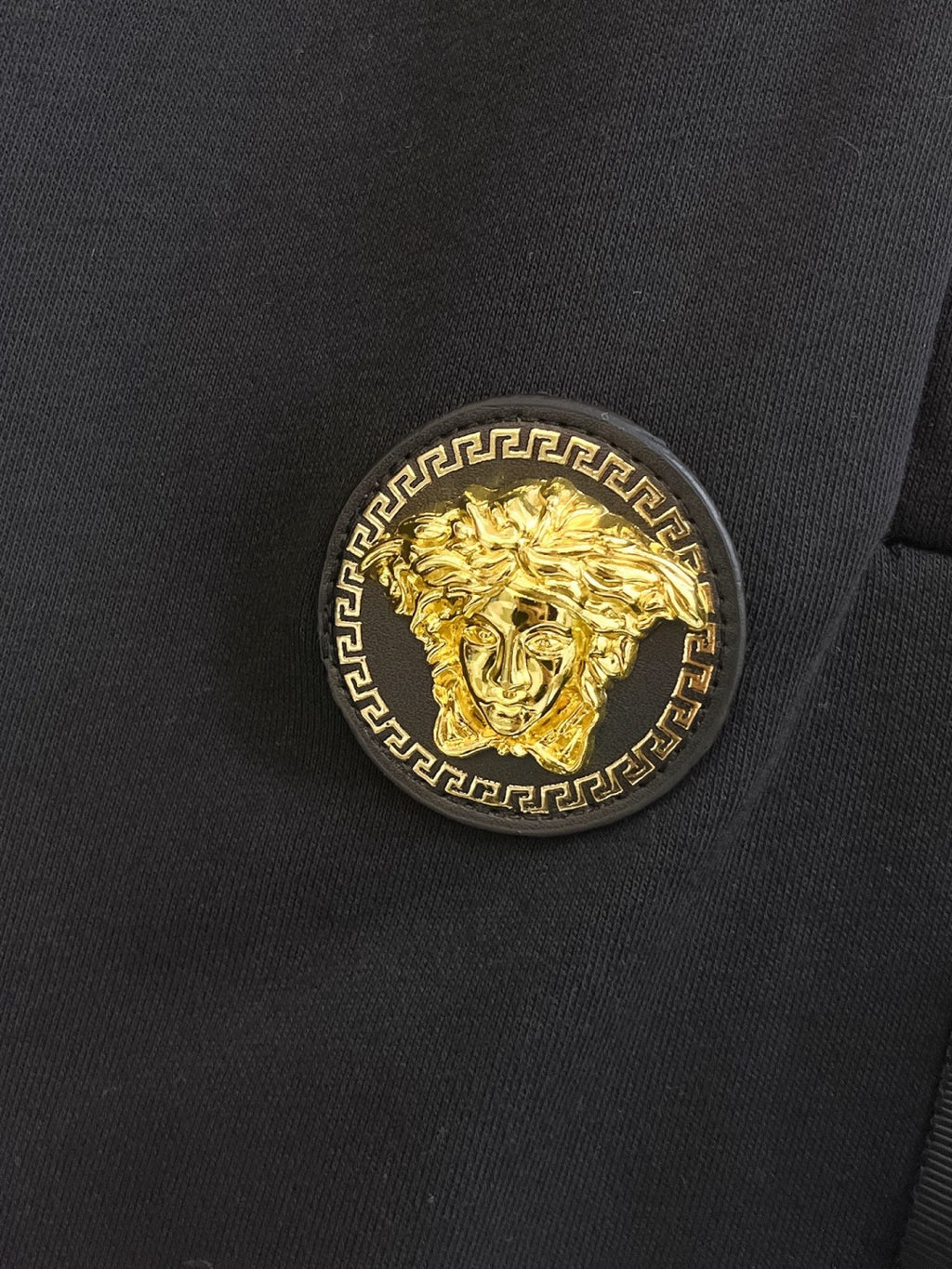Black shorts fabric with gold medallion logo patch