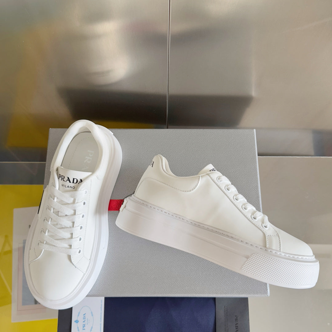 Unisex white leather sneakers on a box with PRADA logo on the heel