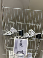 Pair of silver slide sandals with layered buckles and black block heels