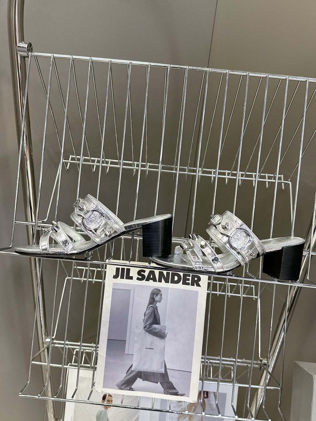 Pair of silver slide sandals with layered buckles and black block heels