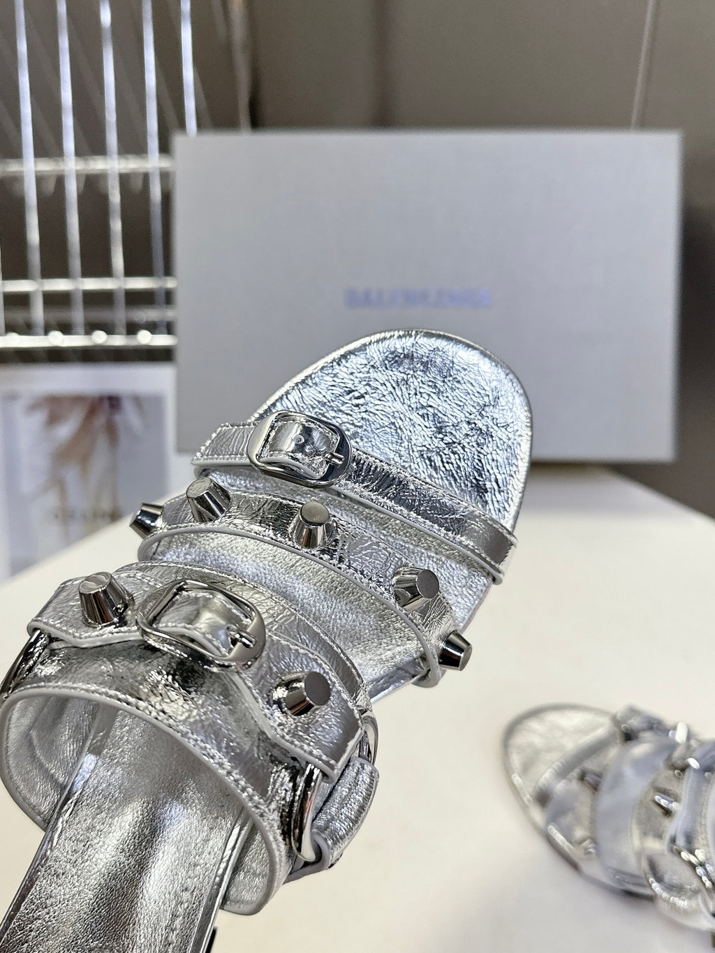 Silver sandal with wide buckled toe strap and textured leather upper