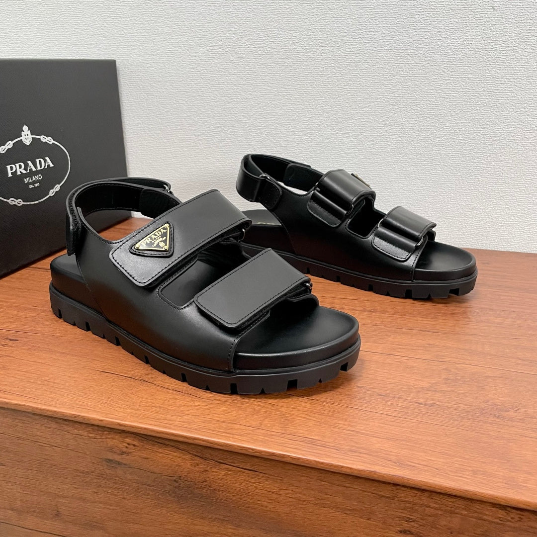 Prada unisex black sandals with two front straps, triangular logo patch, and thick sole