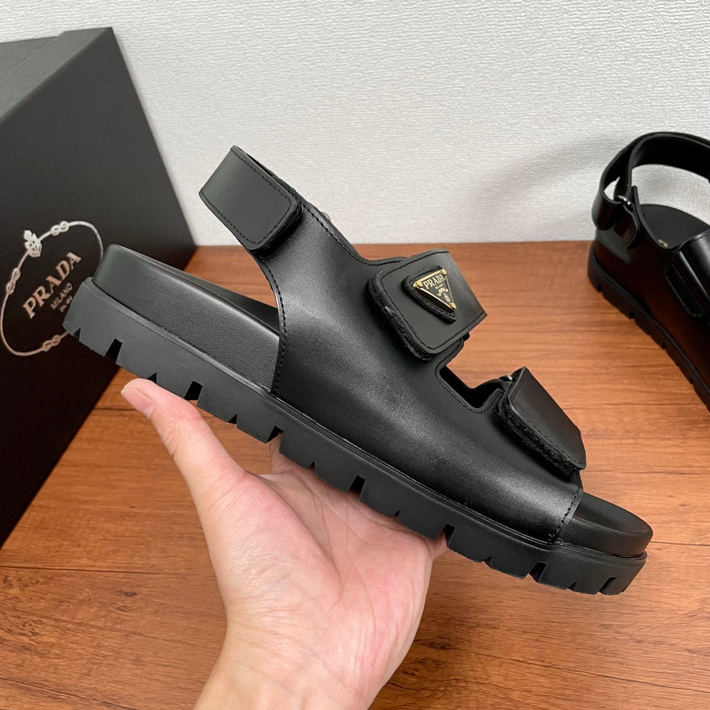 Prada unisex black sandal shown in side view with wide strap and rugged tread outsole
