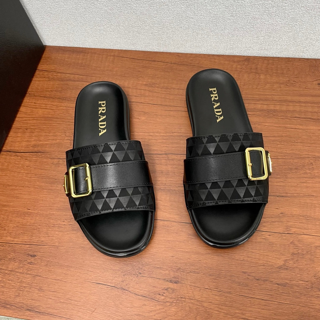 Black Prada slide sandals with wide strap and gold buckle, front view.