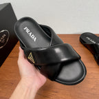 Black slide sandal with PRADA logo on footbed and gold logo patch on strap
