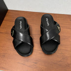 Black Prada slide sandals with wide crisscross straps and gold triangular logo