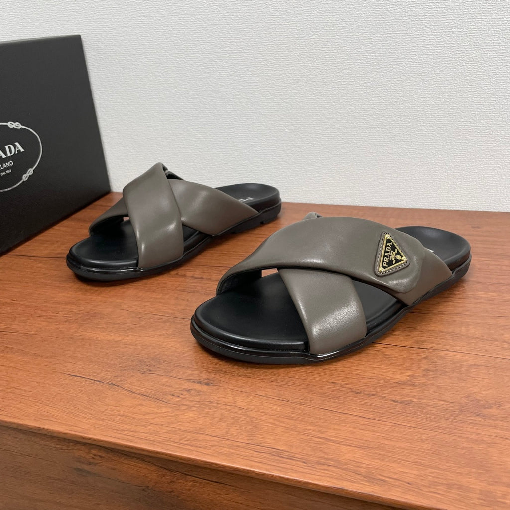 Gray leather Prada slide sandals, black footbed and gold logo plaque (pair)