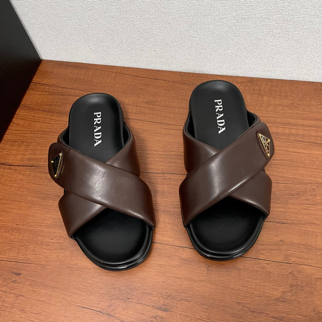 Dark brown cross-strap slide sandals with PRADA text on footbeds and gold logo