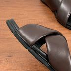 Dark brown slide sandal side view with thick black sole and smooth cross strap
