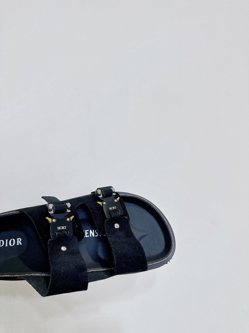 Dior sandals close-up, black straps with metal buckles and insole branding