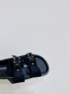 Dior sandals close-up, black straps with metal buckles and insole branding