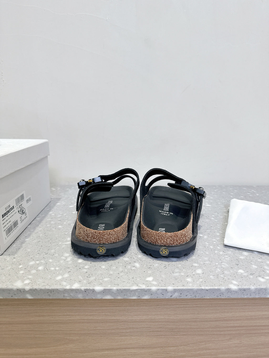 Dior sandals back view, black straps and heel counters with cork-look footbed