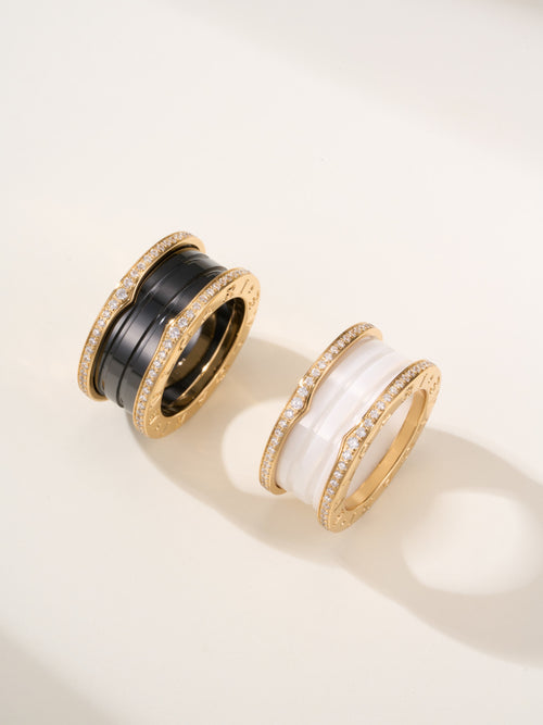 Gold-tone ring pair with black enamel bands and pavé sparkle detailing