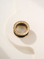 Gold-tone ring with engraved details and gemstone pavé edge, top view