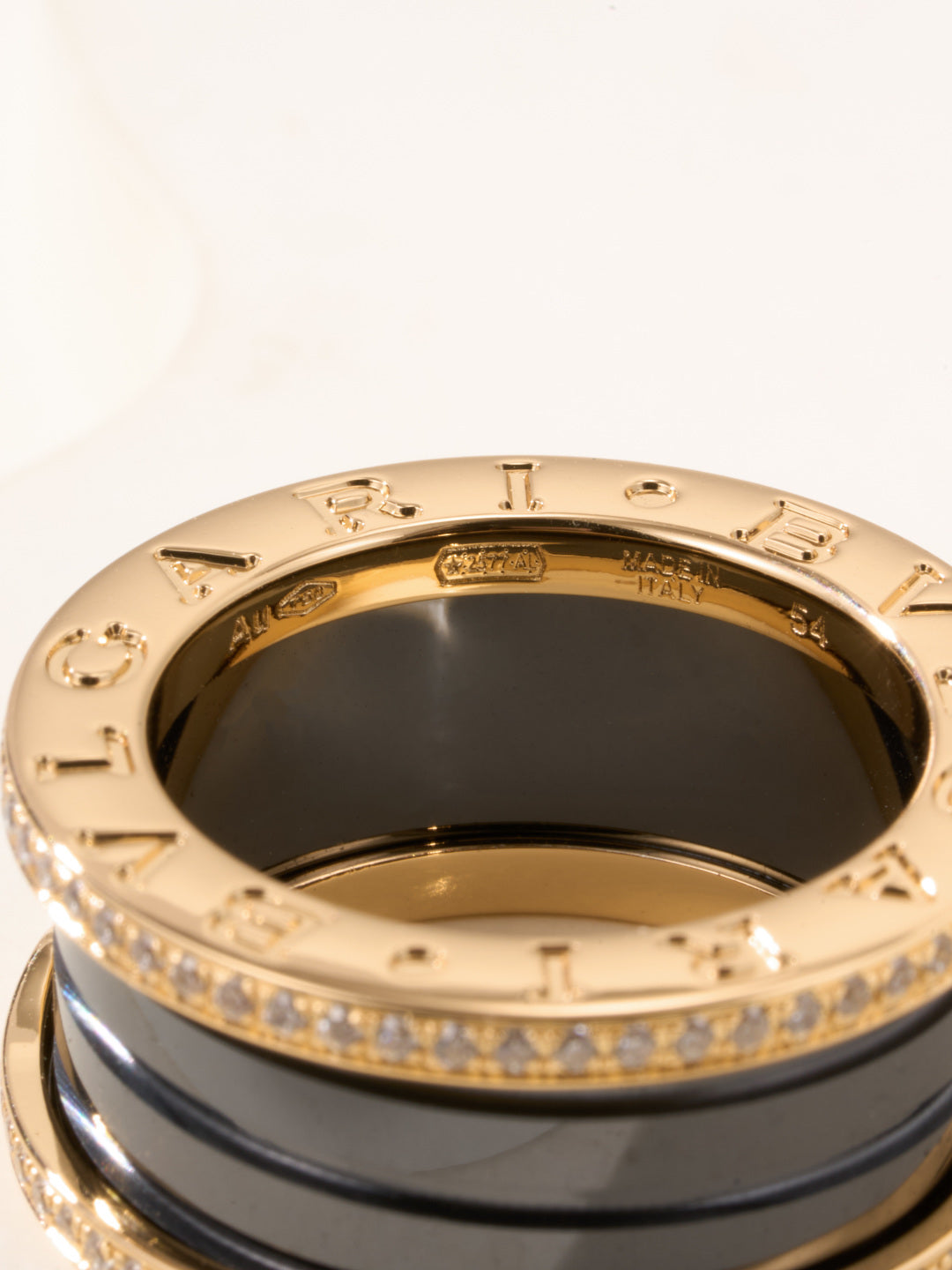 Gold-tone ring inner view with engraved markings and dark enamel center