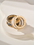 Bvlgari-style gold rings with white and black enamel bands, overlapping view