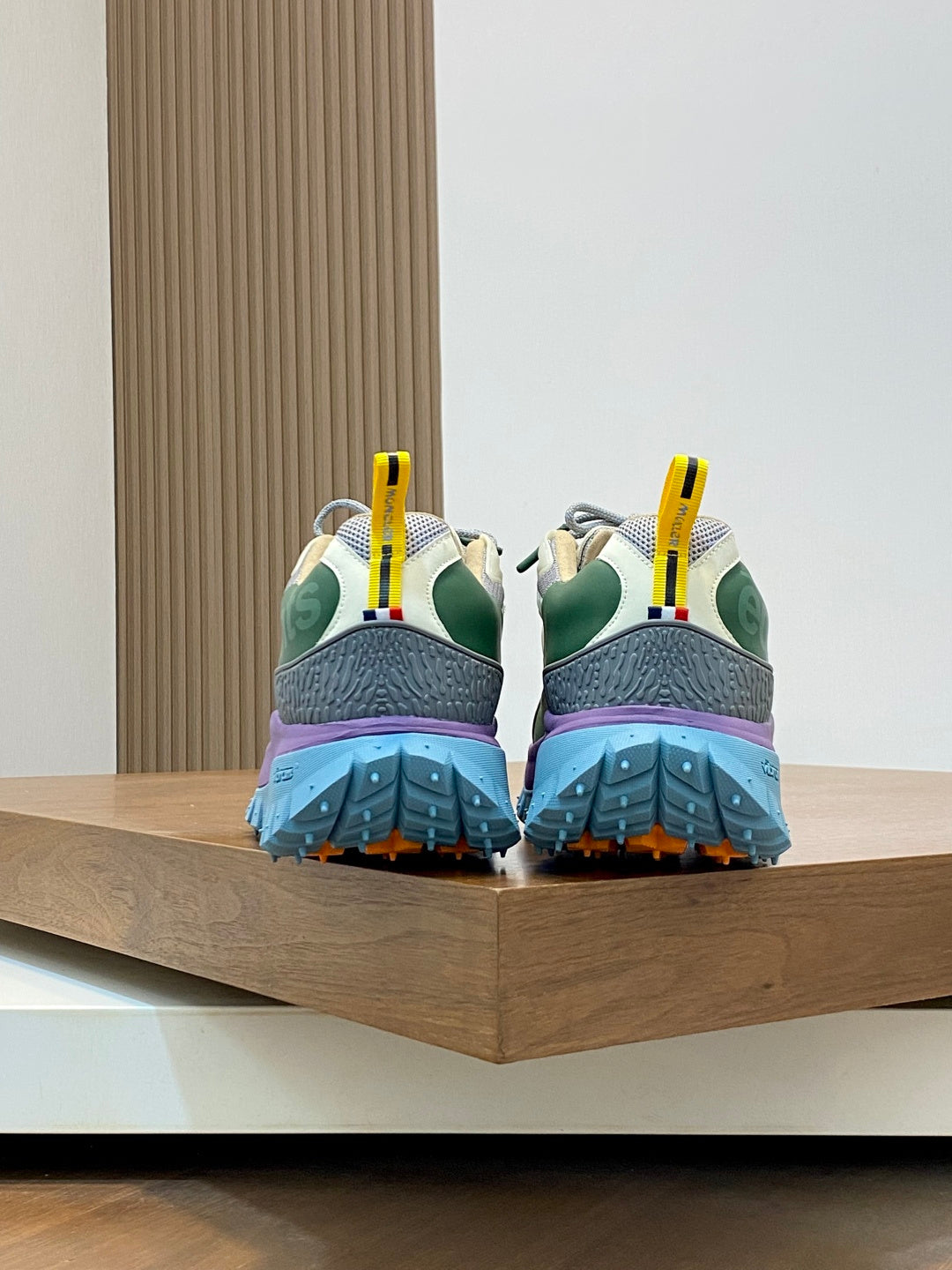 Moncler sneakers back view with purple heel, green accents, and blue sole