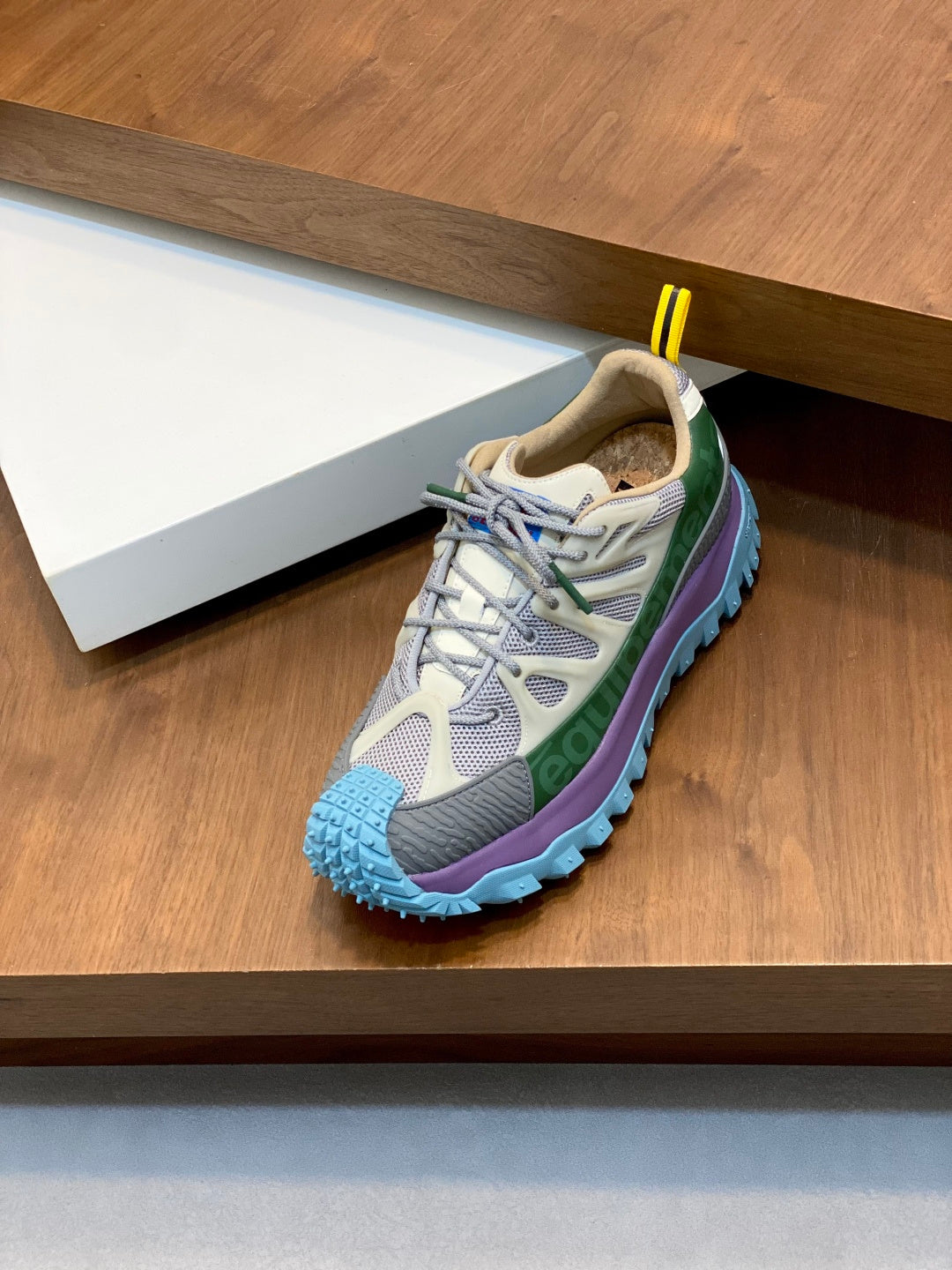 Moncler sneakers with gray upper, green stripe, and blue treaded sole