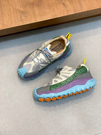 Moncler sneakers pair with gray uppers, green and purple accents, and blue sole