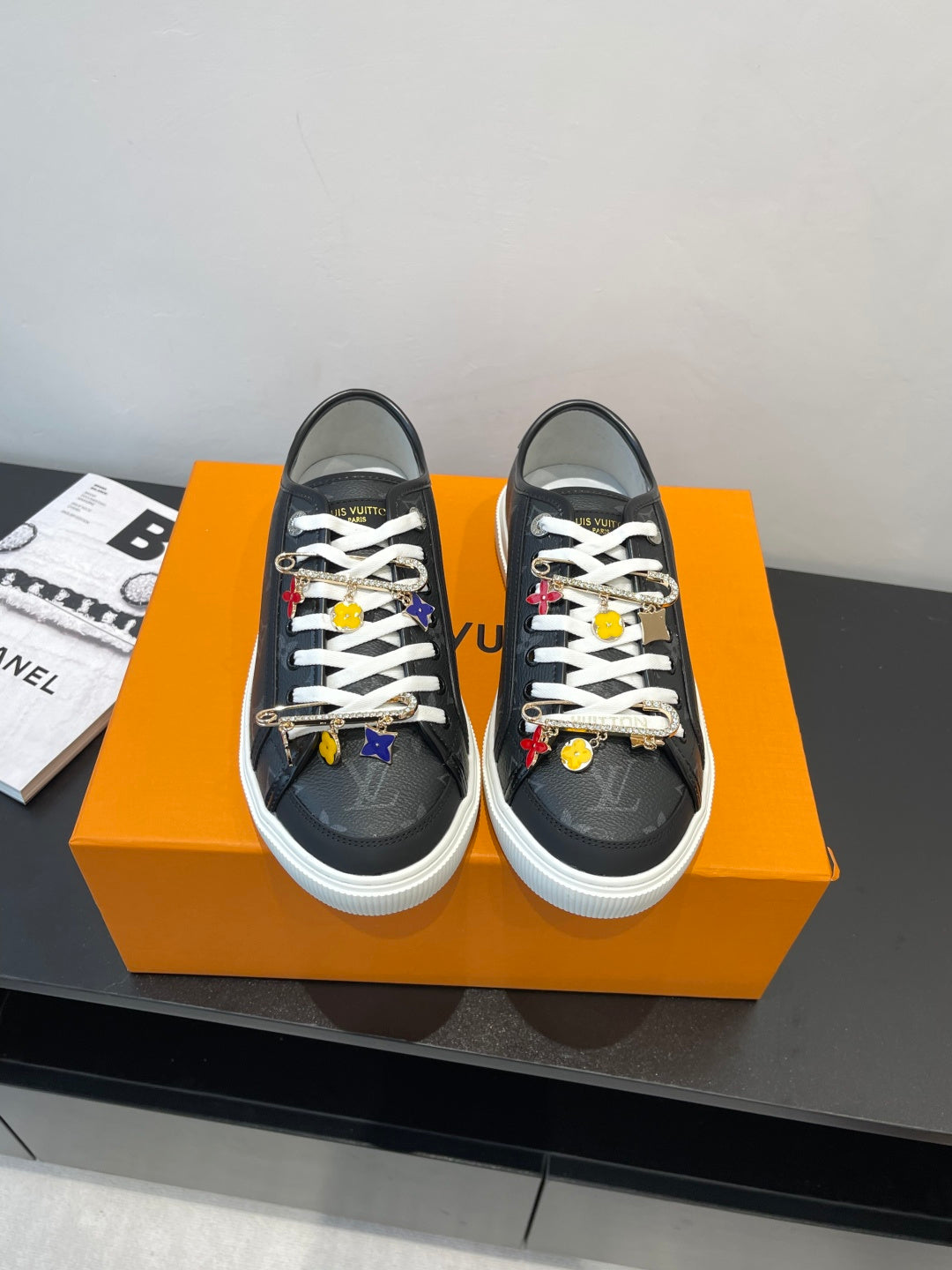 Louis Vuitton low-top sneakers in dark fabric with white laces and colorful charm accents