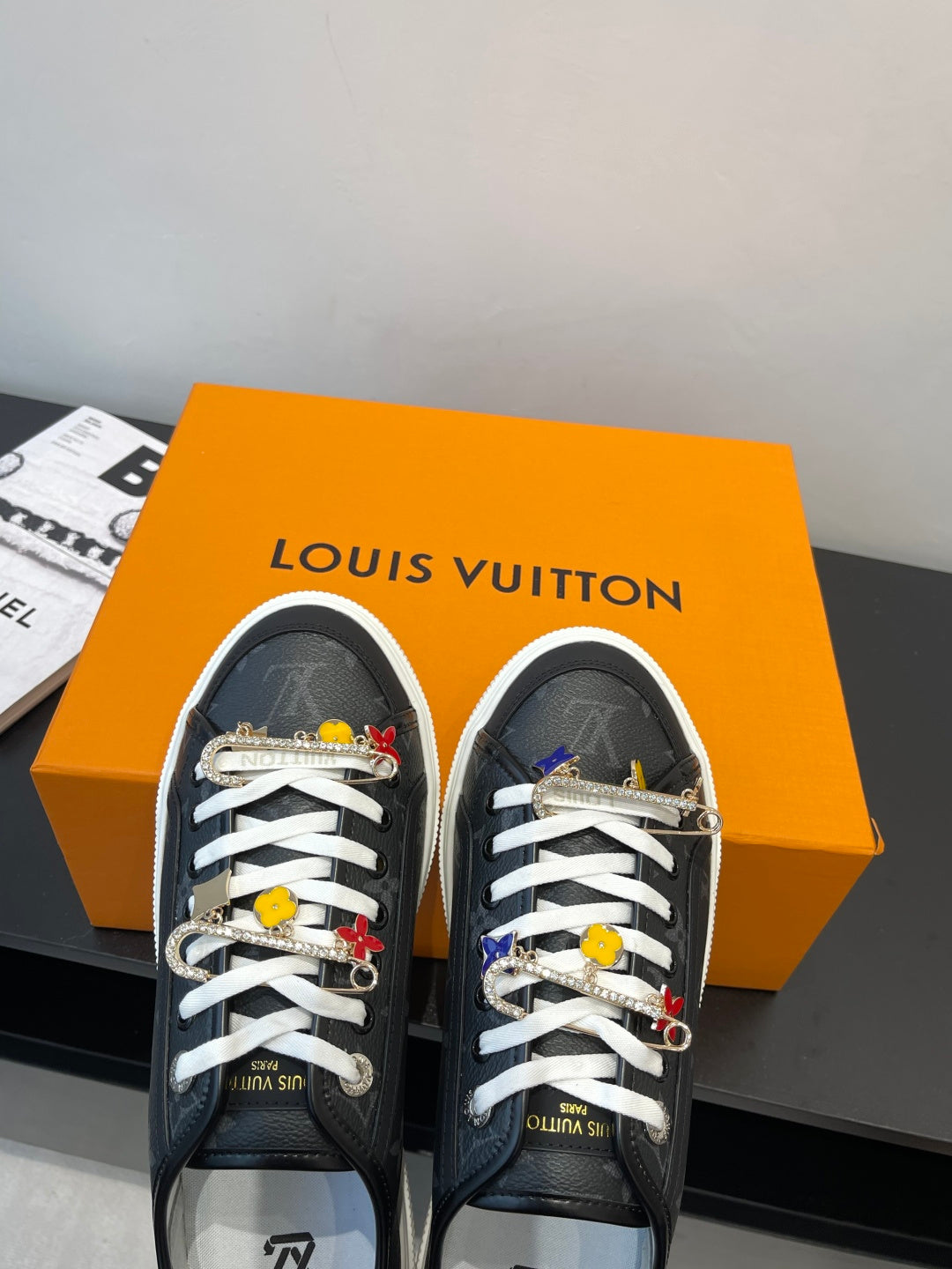 Louis Vuitton low-top sneakers in dark monogram with white laces and hanging charm ornaments
