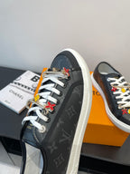 Louis Vuitton low-top sneaker in dark monogram with white laces and multicolor charm tassels