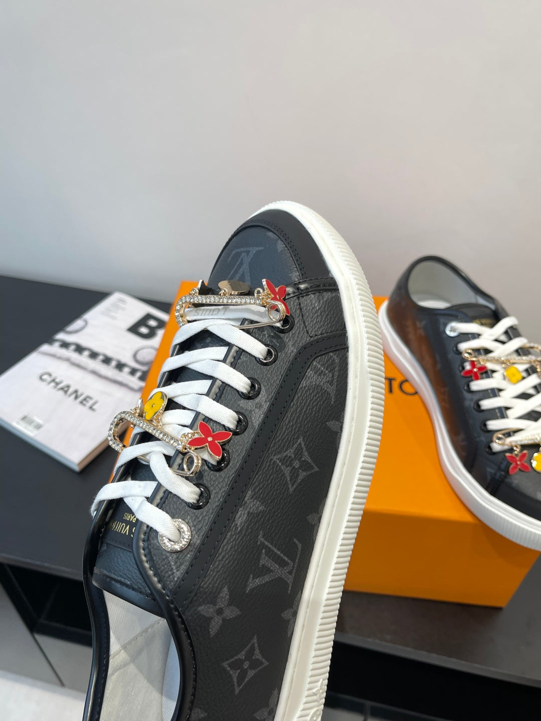 Louis Vuitton low-top sneaker in dark monogram with white laces and multicolor charm tassels