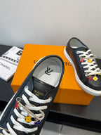 Louis Vuitton low-top sneaker with dark monogram, white laces, and decorative charm hardware
