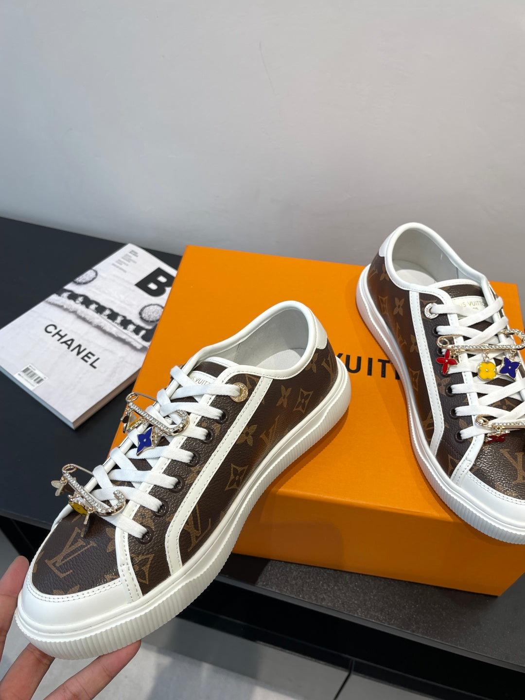 Louis Vuitton lace-up sneakers with brown monogram pattern, white stitching, and white rubber sole