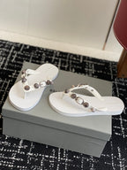 White Balenciaga thong sandals with metallic buckle and studded straps
