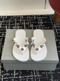 White thong sandals with metallic buckle and circular stud straps