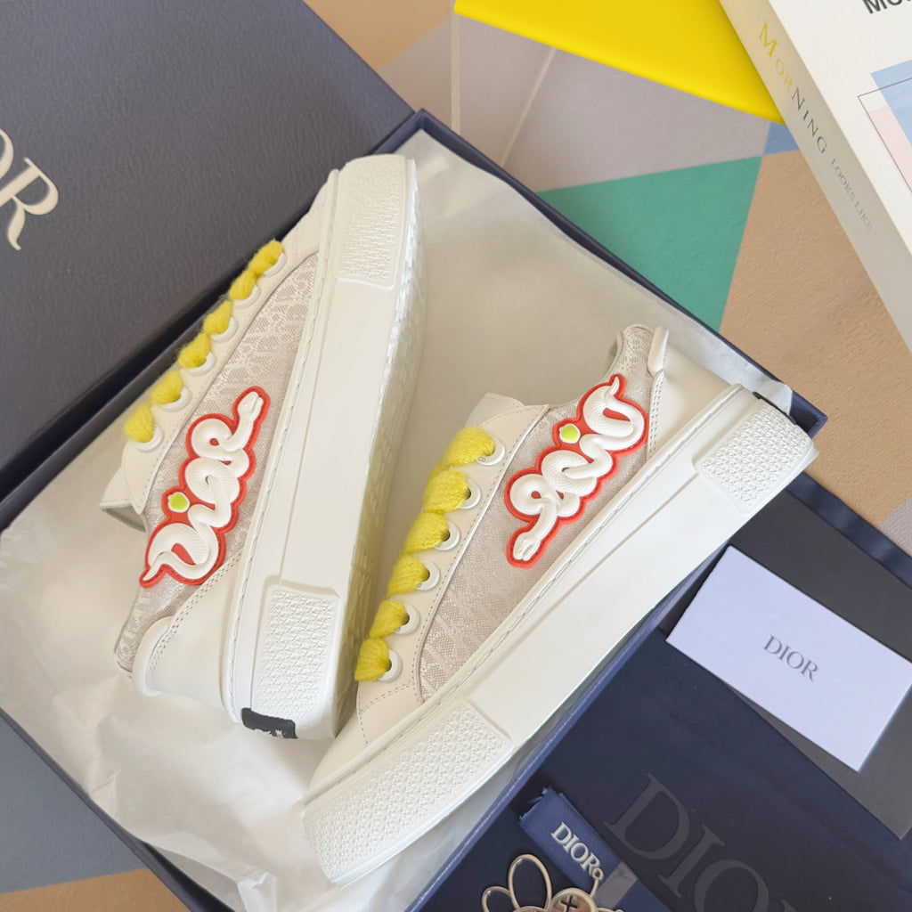Unisex white platform sneakers with yellow laces and red script side logo