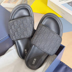 Dior slide sandals, close view of jacquard logo strap over dark gray footbeds