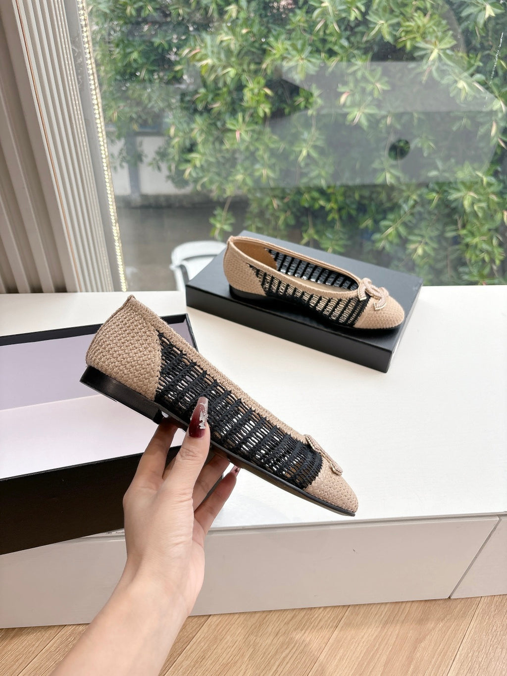 Chanel woven ballet flats on display with black knit side stripe and beige upper