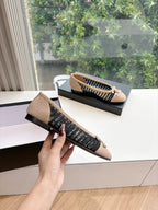 Chanel woven ballet flats on display with black knit side stripe and beige upper