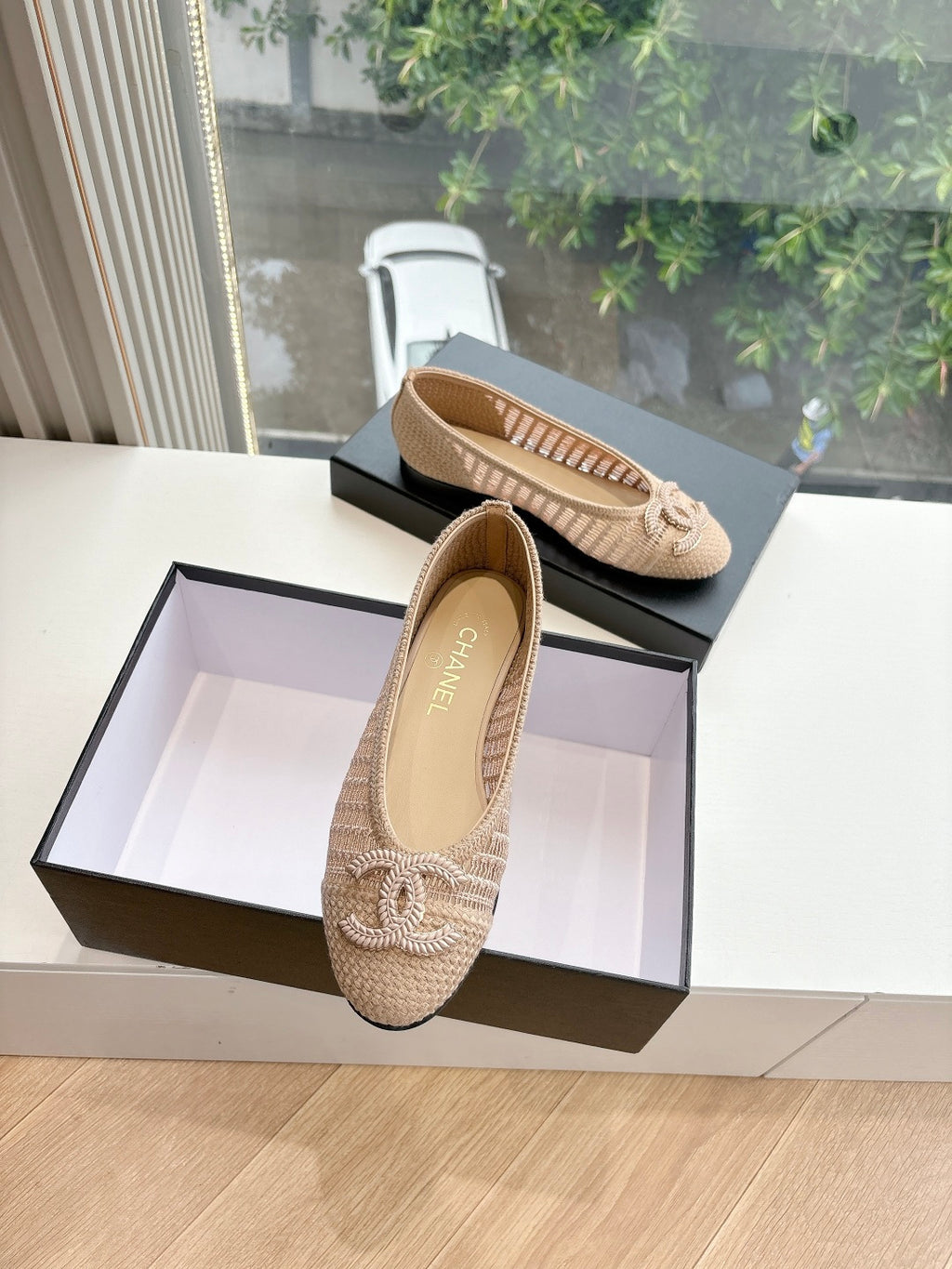 Beige woven ballet flats with braided bow detail, shown from side with open shoe.