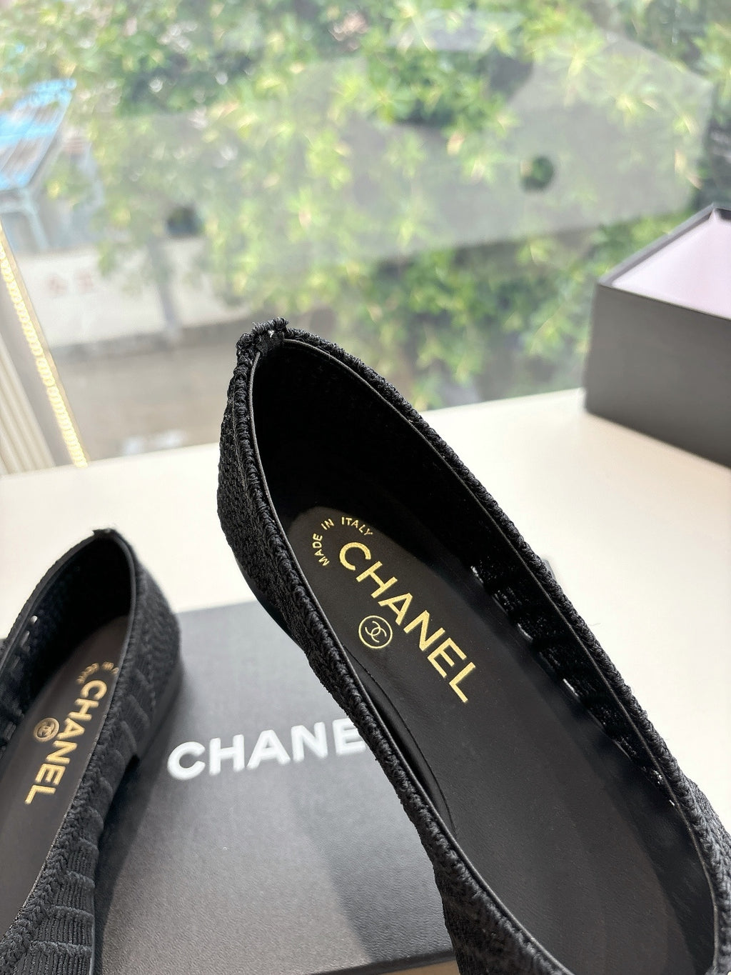 Black Chanel knit slip-on flats showing CHANEL insole lettering and toe seam