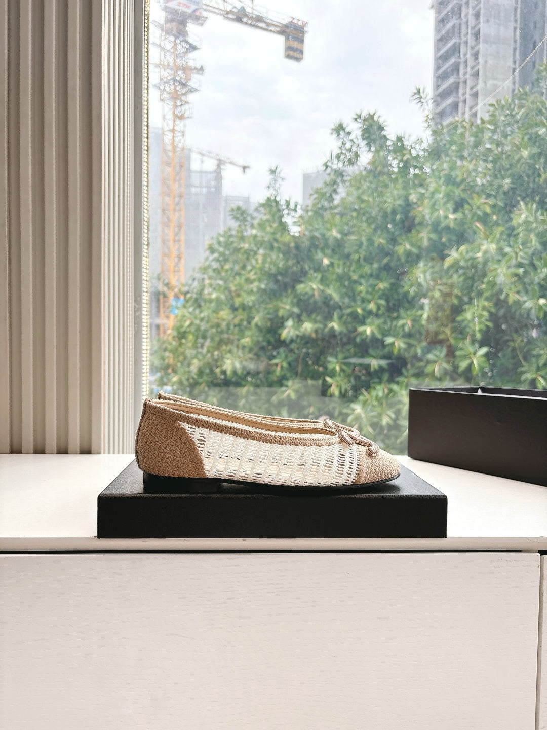 Chanel ladies beige woven ballet flat on a black shoebox